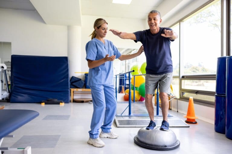 Occupational therapist supporting a man doing his exercises