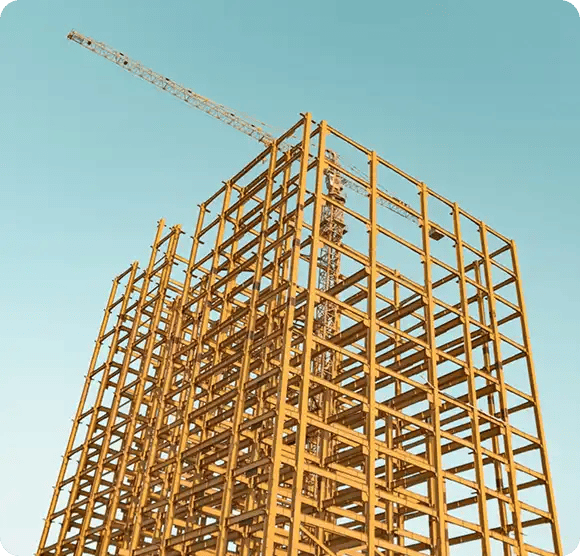 A tall yellow steel building framework under construction against a clear blue sky, serving as a metaphor for the structured support and capacity building provided by Jango’s psychosocial recovery coaches.