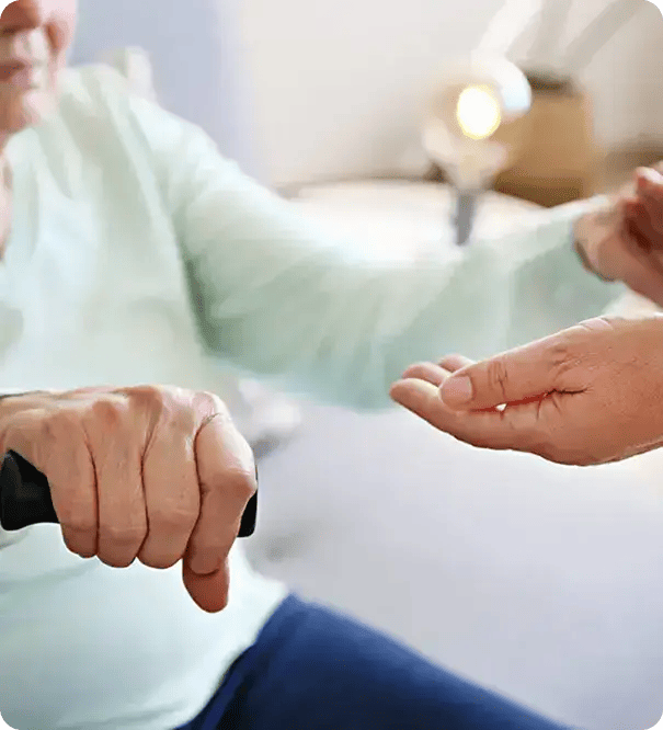 A close-up of a support worker’s hand gently reaching out to assist an elderly person holding a walking cane, illustrating Jango’s commitment to providing compassionate, physical assistance to help participants maintain their mobility and independence.