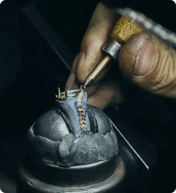 A close-up, detailed view of a jeweler using a precision tool to set small stones into a gold ring, serving as a metaphor for Jango’s meticulous and "hand-crafted" approach to NDIS support coordination in Brisbane.