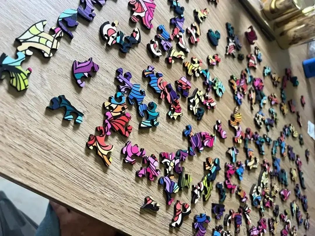 A collection of vibrant, patterned wooden puzzle pieces on a table, representing cognitive skill development and engaging therapeutic activities offered through Jango Community Services.