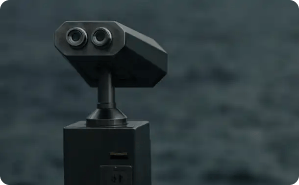 A set of black stationary observation binoculars overlooking a soft-focus background, symbolizing the long-term career vision, professional growth, and future-focused opportunities for employees joining the Jango team.